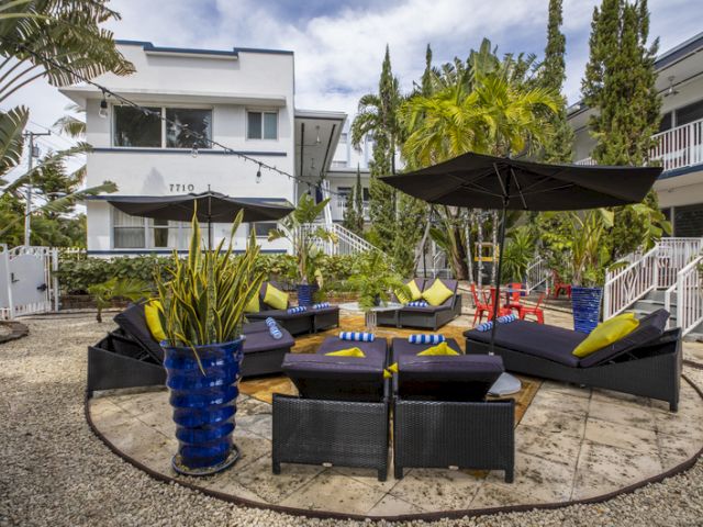 A seating area with outdoor furniture and umbrellas in a landscaped courtyard.
