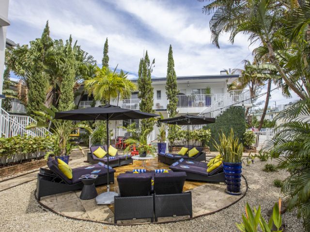 a seating area with outdoor furniture and umbrellas